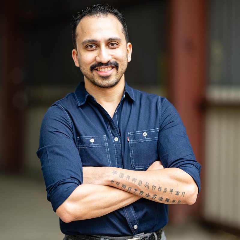 Alex Baqui standing with arms crossed